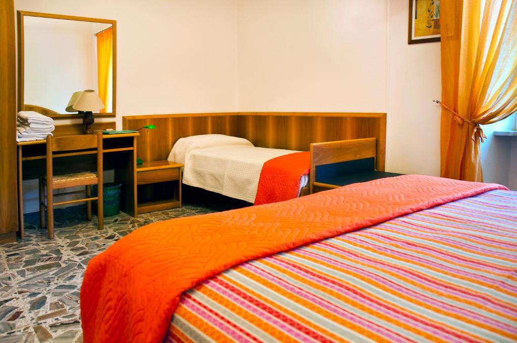 sypialnia z 2 łóżkami, biurkiem i lustrem w obiekcie B&B Il Colle w mieście Serra San Quirico