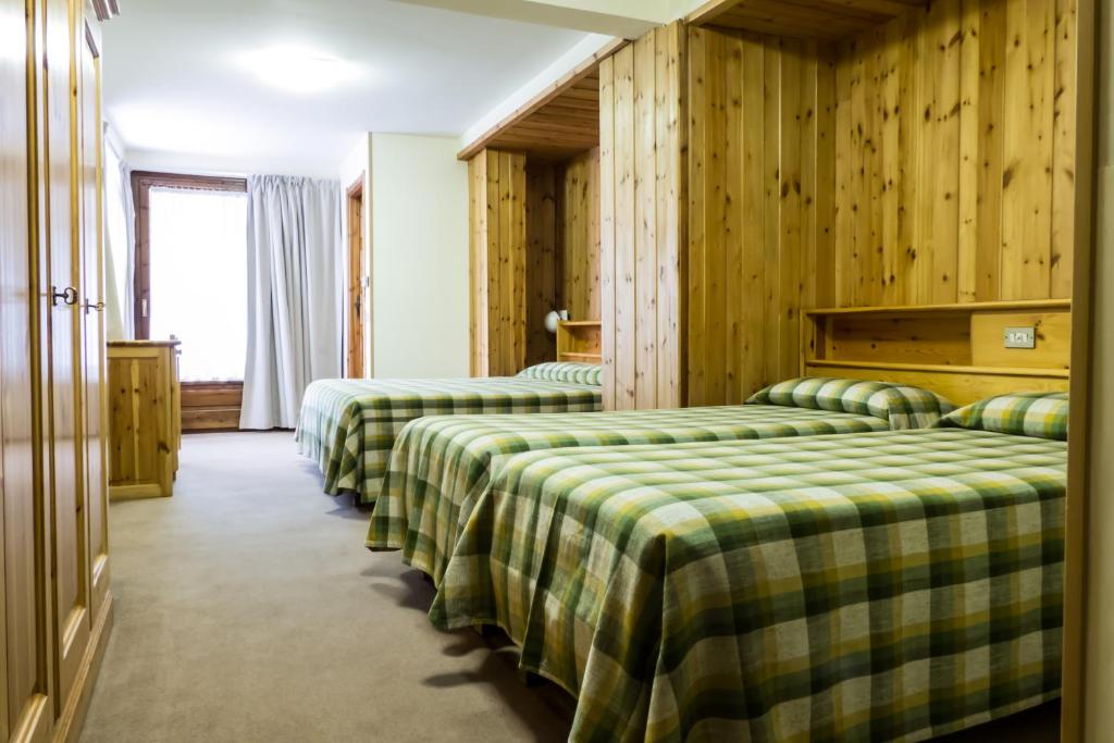 Łóżko lub łóżka w pokoju w obiekcie Hotel Valdotain