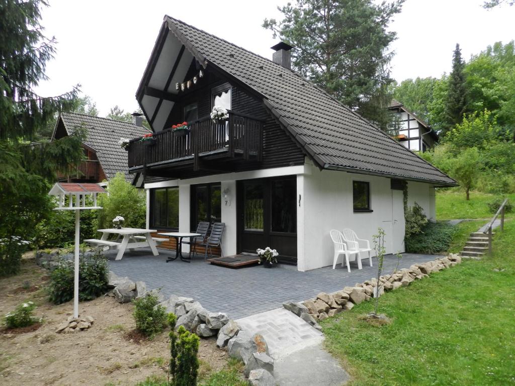 FrankenauにあるFerienhaus Ericaの小さな白い家で、パティオとテーブルが備わります。