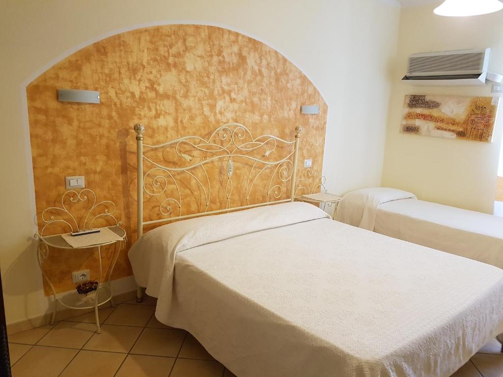 una camera da letto con un letto con testiera in legno di B&B da Anna a Bosa