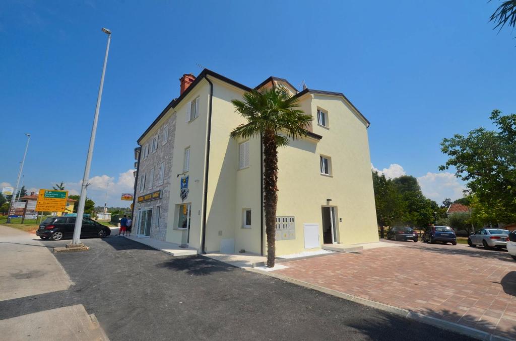una palmera frente a un edificio blanco en Stella Apartments en Novigrad Istria