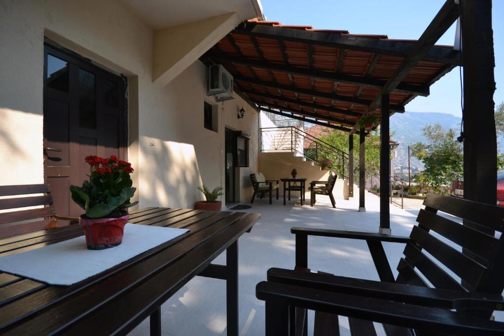 a patio with a wooden table and chairs on a porch at Apartments Dionis in Kotor