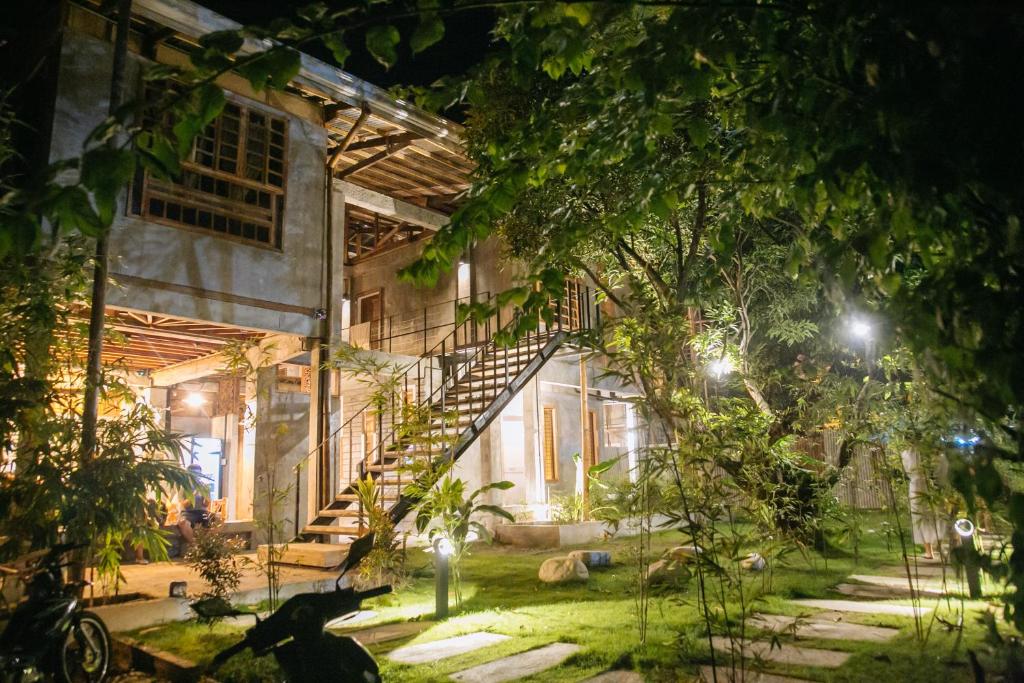 a building with a staircase in the yard at night at The Flying Fish Hostel in Dumaguete
