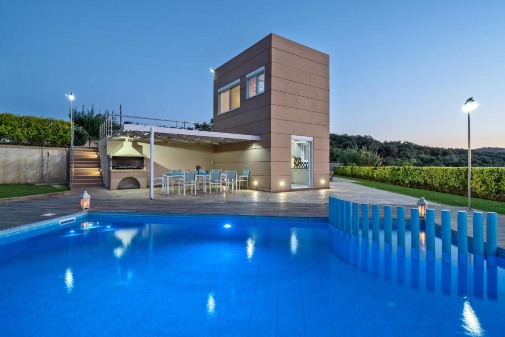 a house with a swimming pool in front of a house at Villa Ariella in Agia Marina Nea Kydonias