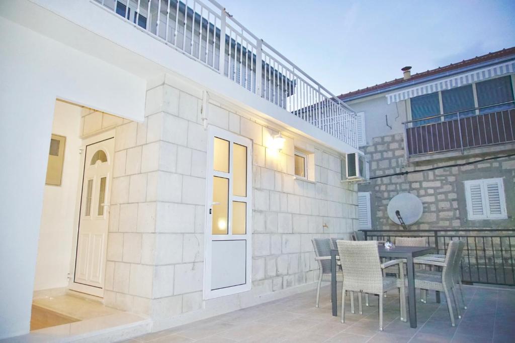 eine Terrasse mit einem Tisch und Stühlen sowie ein Gebäude in der Unterkunft Puerto Tranquilo beach Residsnce in Trogir
