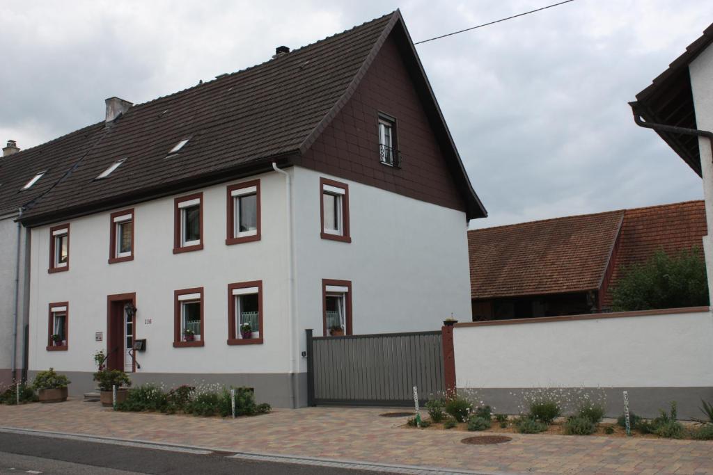 ein weißes Haus mit braunem Dach in der Unterkunft Ferienwohnung Fam. Höhn in Kappel-Grafenhausen