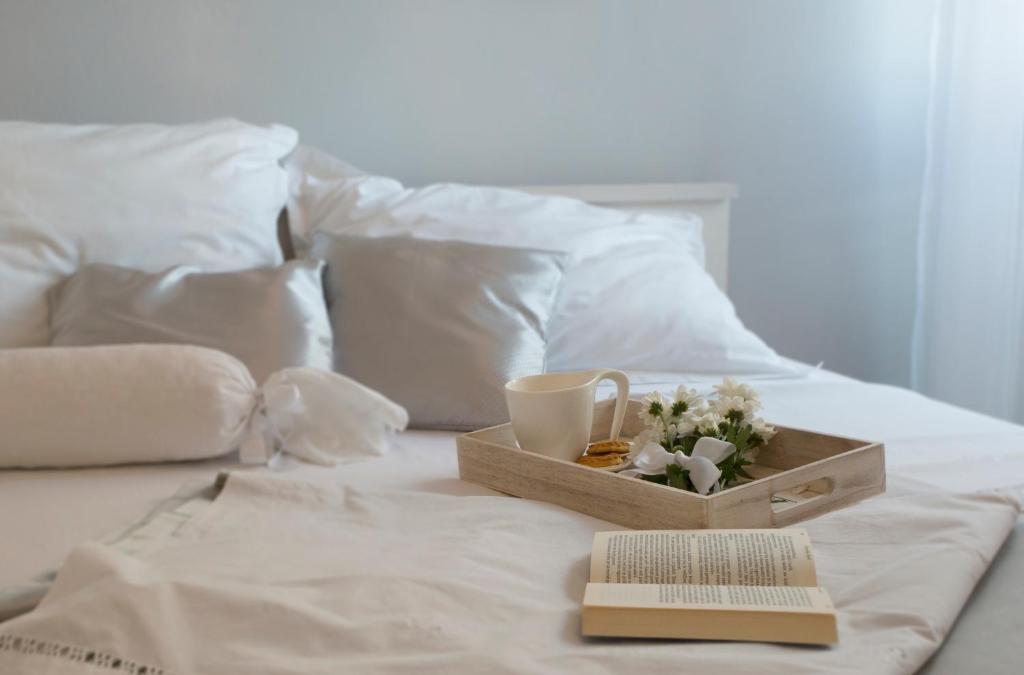a tray of flowers and a cup and a book on a bed at Apartment Lana in Split