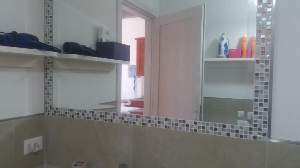 La salle de bains est pourvue d'un miroir et d'un lavabo. dans l'établissement La Porta sul Lungomare, à Castelsardo