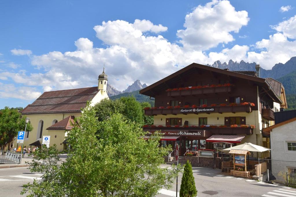 un edificio con una torre de reloj en una ciudad en Aurturist Miramonti S Candido, en San Candido