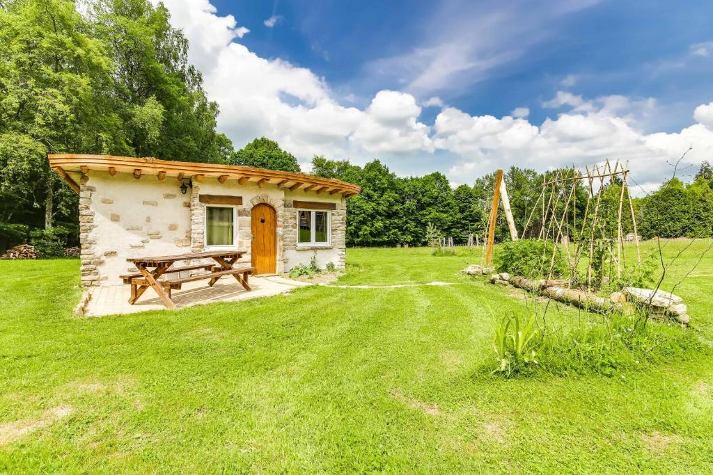 Cabaña pequeña con mesa de picnic en un campo en La Clairière du Verbamont, en Claudon