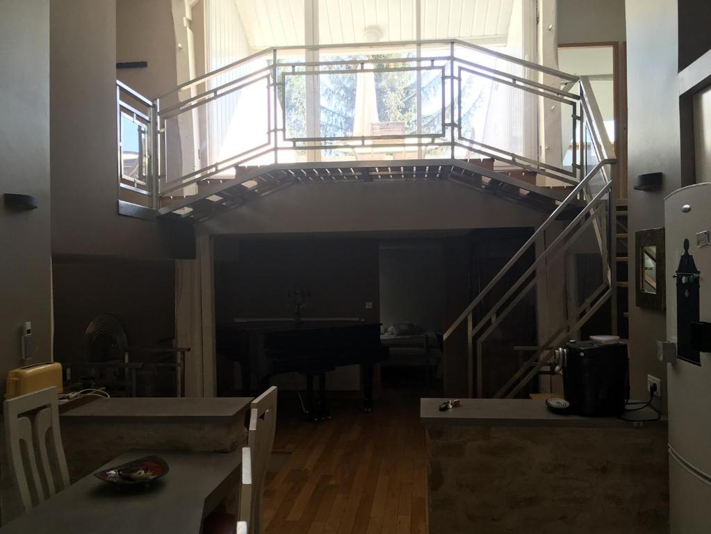 - un escalier dans un salon avec un balcon dans l'établissement la grange, à Jeuxey