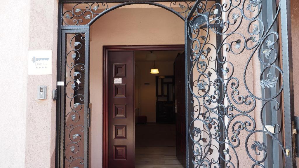 an entrance to a house with a wrought iron door at Guest house DON-lux in Pljevlja