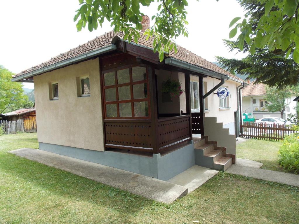 a small house with a porch and stairs in a yard at Apartment Matogi in Mokra Gora