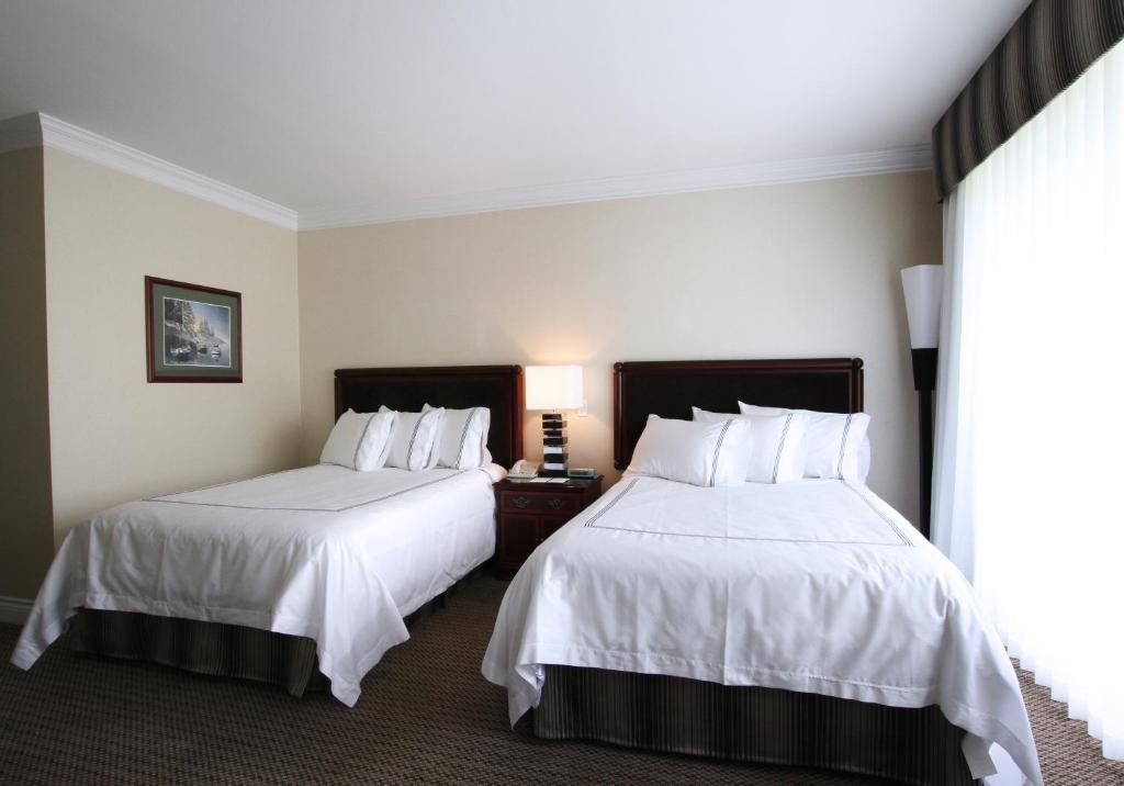 a hotel room with two beds and a window at Granville Island Hotel in Vancouver