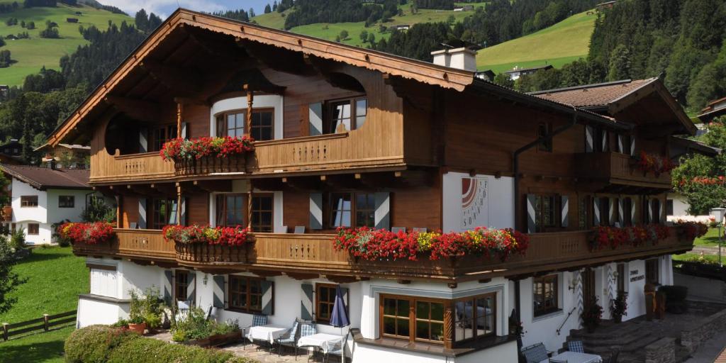 a building with flowers on the balconies of it at Pension Sonnhof in Brixen im Thale