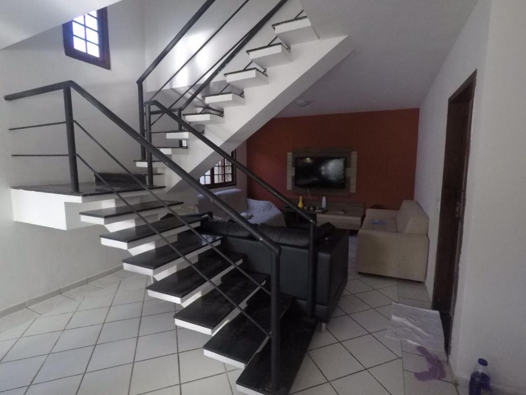 a spiral staircase in a room with a living room at Casa em Ponta Negra in Natal
