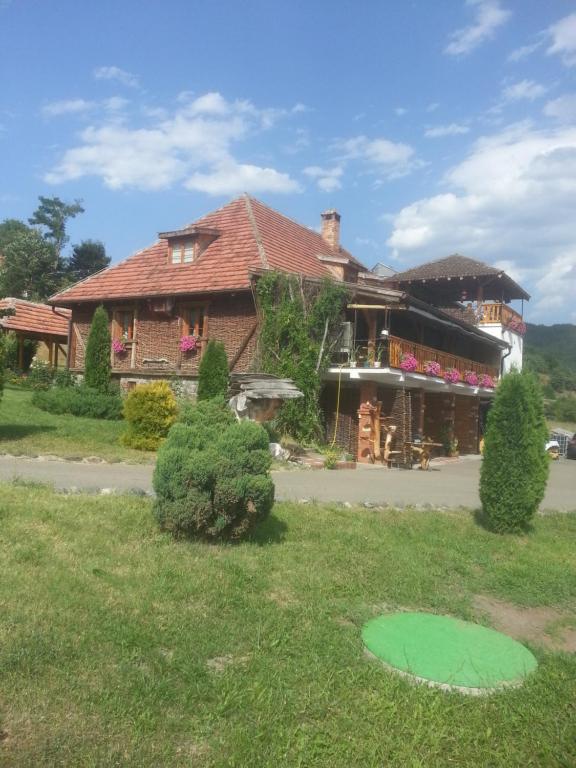 a house with a green circle in the grass at Inn Cakmara in Raška