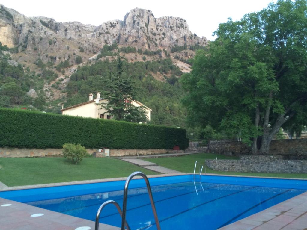 a swimming pool in front of a mountain at Hotel Rural Riogazas in Cazorla