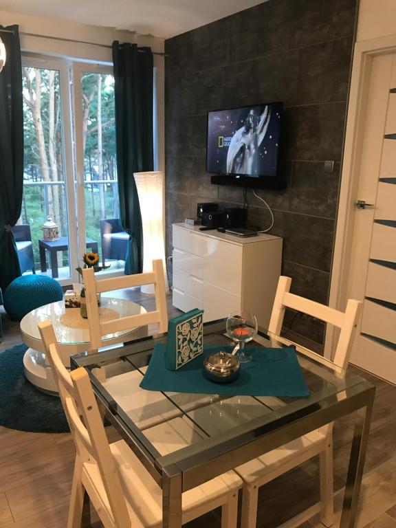 a dining room with a table and a tv at Blue Porta Mare in Dziwnówek