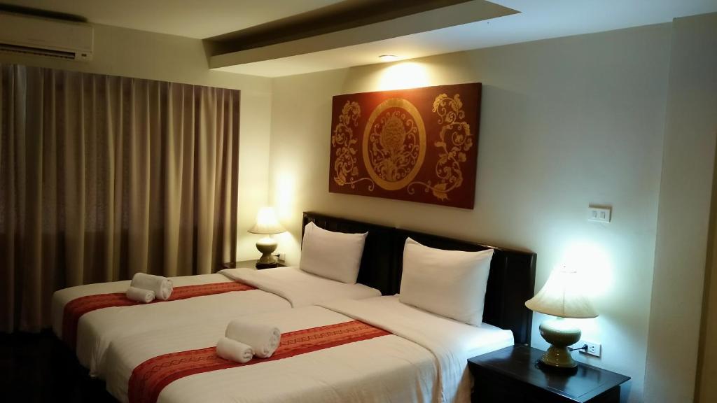 una camera d'albergo con due letti e due lampade di Swankaburi Boutique Hotel a Sawankhalok