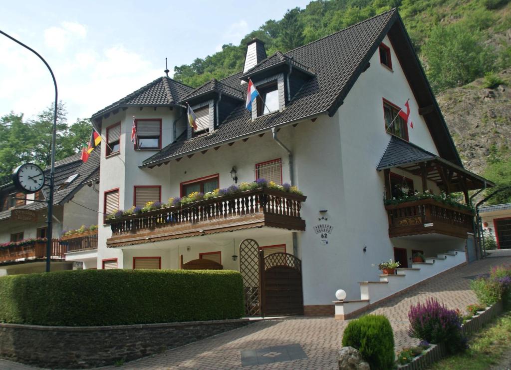 a white house with a clock on the top of it at Pension Belzer in Boppard