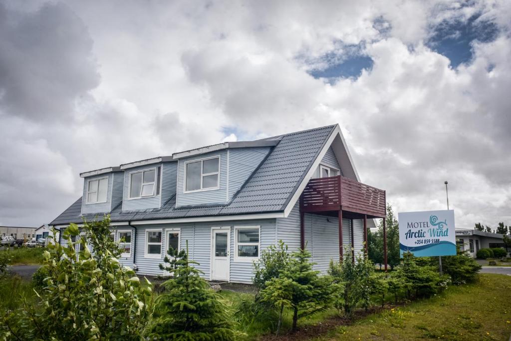 Motel Arctic Wind في Vogar: منزل أمامه لافته