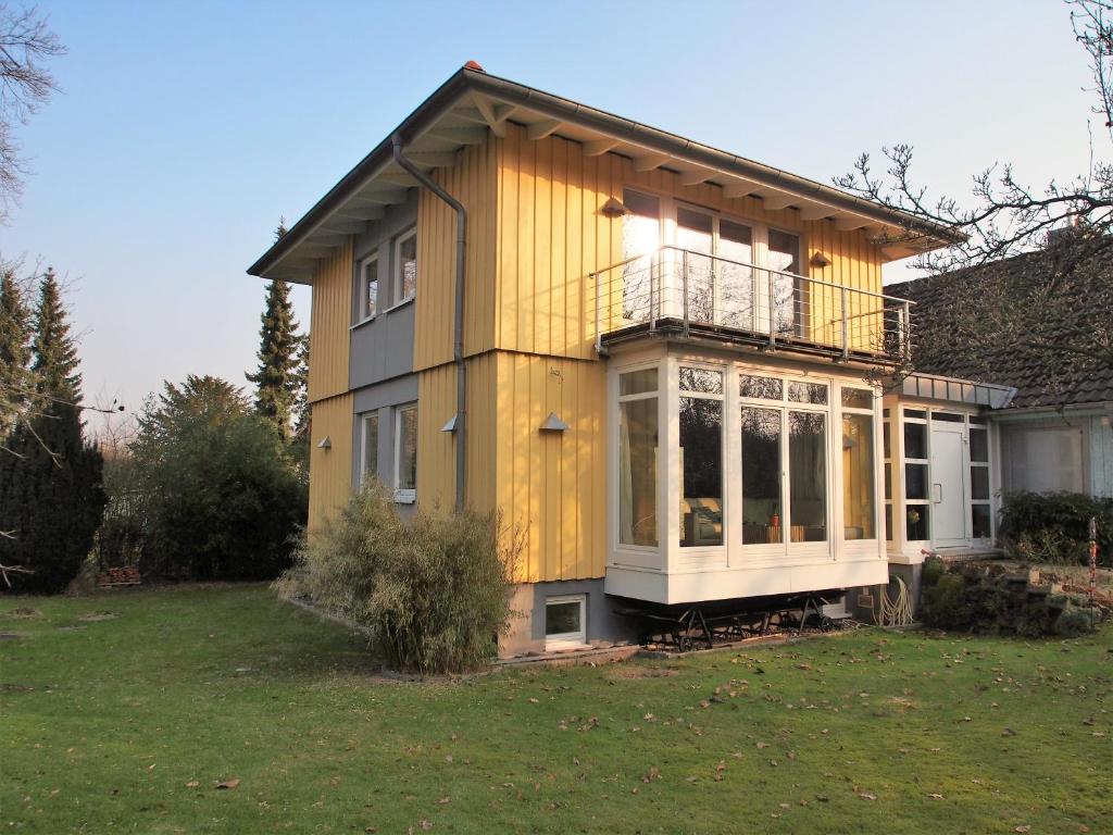 ein gelbes Haus mit einer Veranda auf einem Hof in der Unterkunft "Buena Vista" Ashausen/Hamburg in Stelle