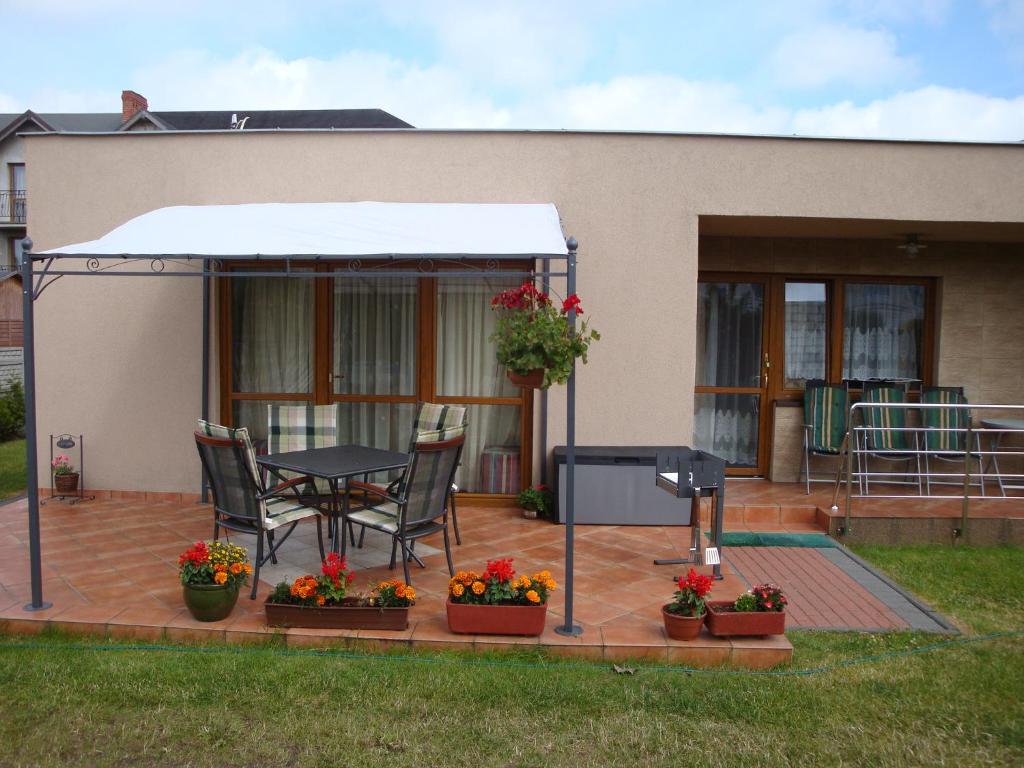 un patio con tavolo, sedie e una casa di Domki-Apartamenty HALS a Władysławowo