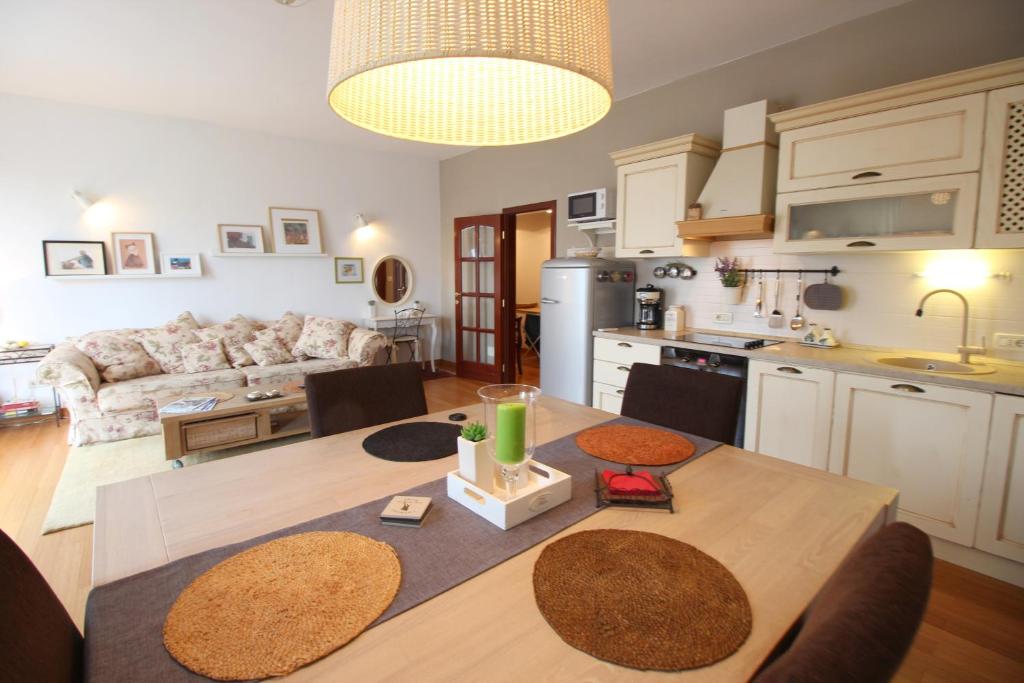 eine Küche und ein Wohnzimmer mit einem Esstisch, einer Küche und einem Wohnzimmer in der Unterkunft Romantic Apartment Pusta in Rovinj