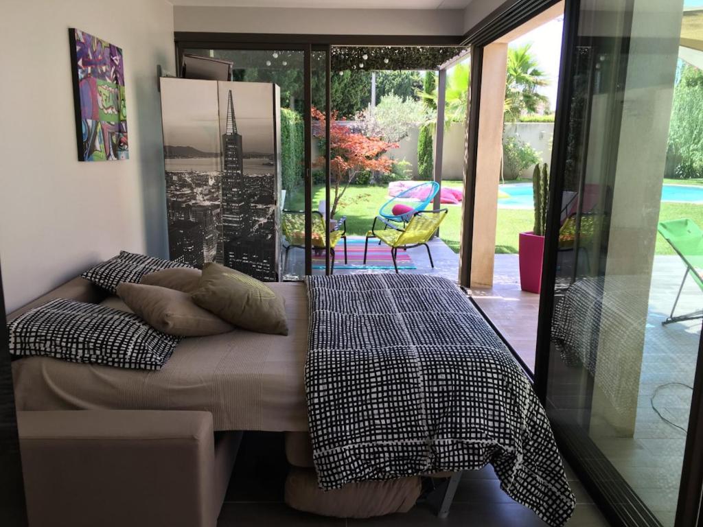 a bedroom with a bed and a view of a patio at Guest House Ginoux in Rognonas