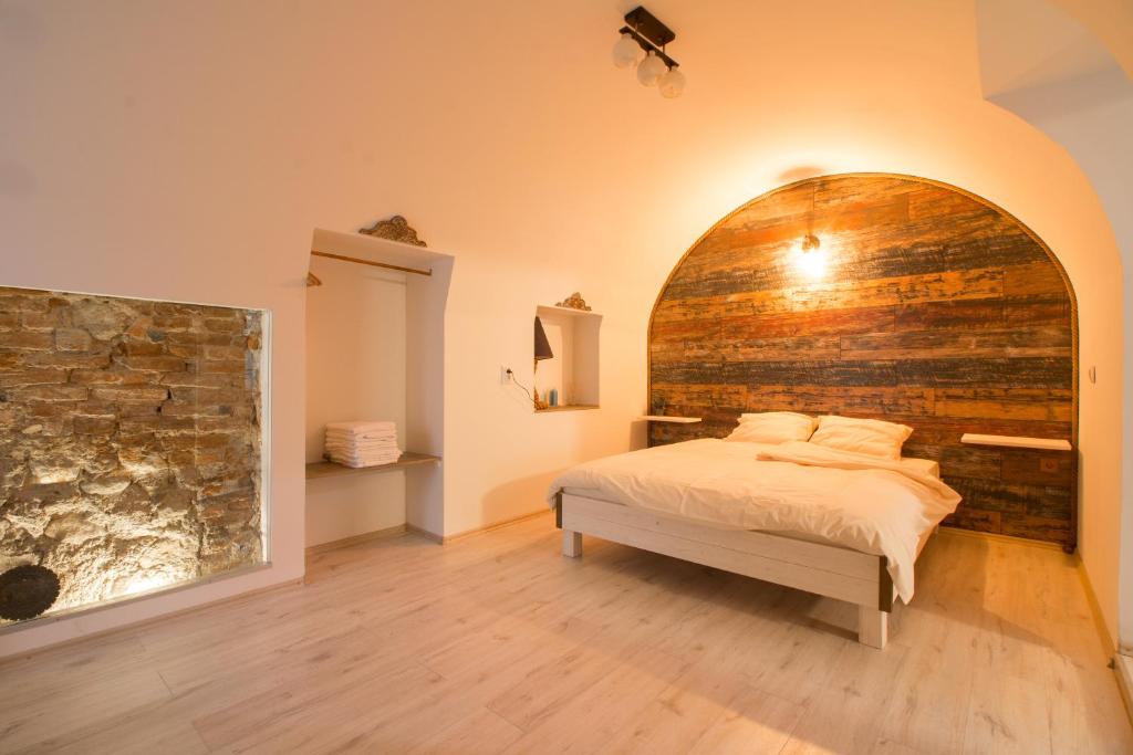 a bedroom with a bed and a brick wall at Poarta Schei apartment in Braşov
