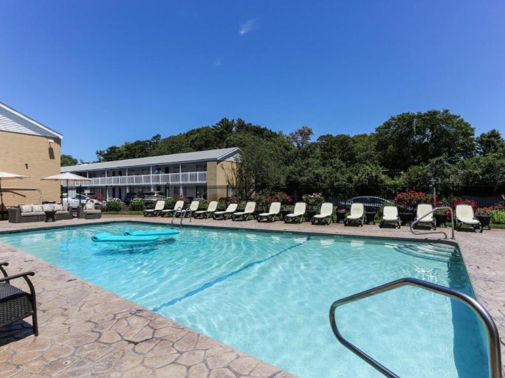 a large swimming pool with chairs and a building at Cape Colony Inn in Provincetown