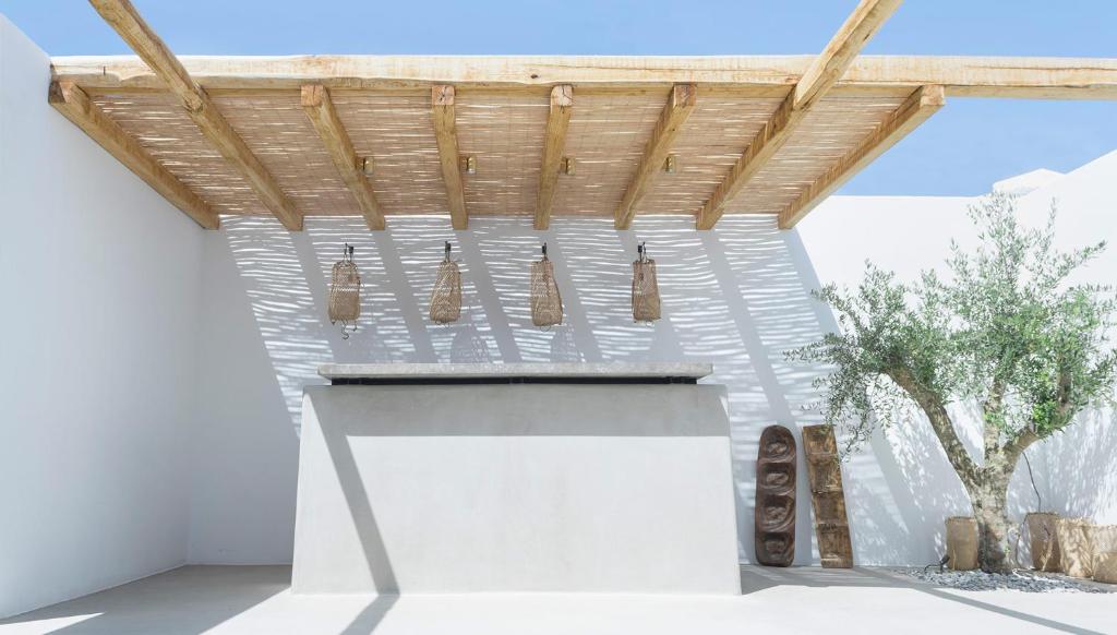 a fireplace in a white room with a wooden roof at Branco Mykonos in Platis Gialos