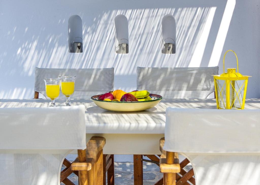 uma mesa com uma taça de fruta e dois copos de sumo de laranja em Glarontas em Galissas