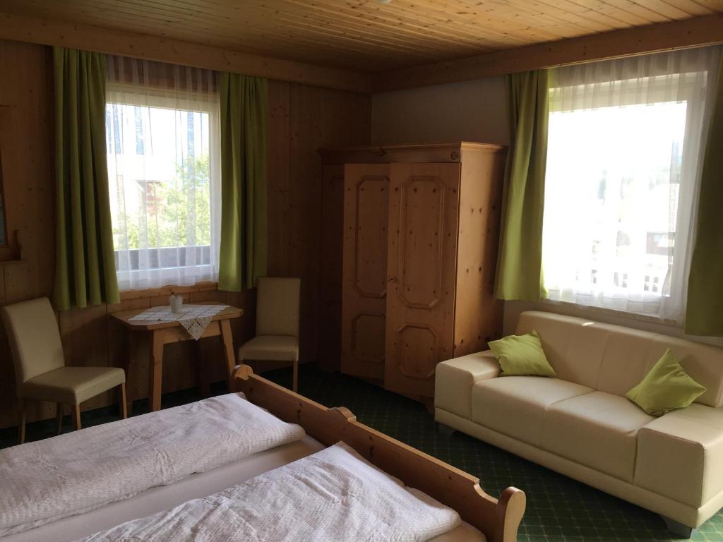 un soggiorno con divano, letto e tavolo di Gästehaus Lemmerer a Obersdorf
