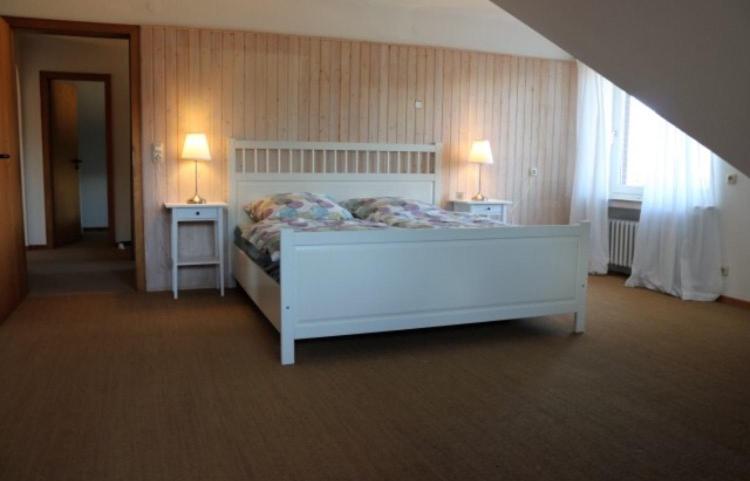 a bedroom with a white bed and two night tables at Ferienwohnung Hämelschenburg in Emmerthal