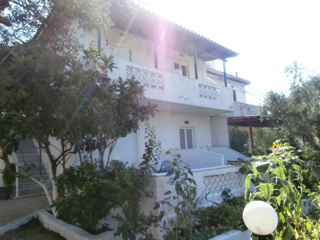 une maison blanche où le soleil brille dans l'établissement Billy's Amoudi Apartments, à Amoudi