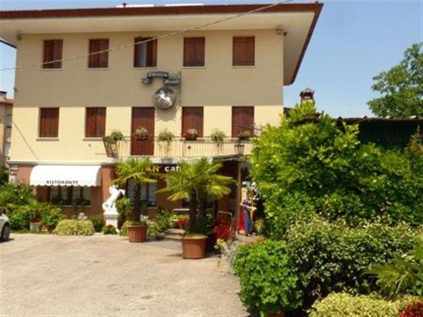 ein großes Gebäude mit Pflanzen davor in der Unterkunft Al Cavallino Bianco in Tricesimo