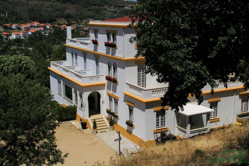 ラメーゴにあるCamping Lamego Douro Valleyの黄色の縁取り付き白い大きな建物