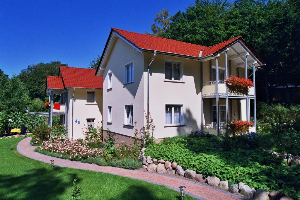 una casa con techo rojo y patio en Ferienhaus zum Südstrand, en Ostseebad Sellin