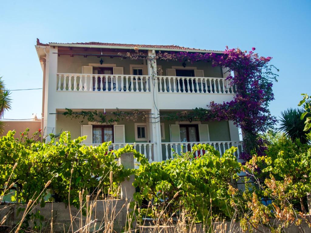 a house with flowers on the side of it at Eleni's Studios in Katelios