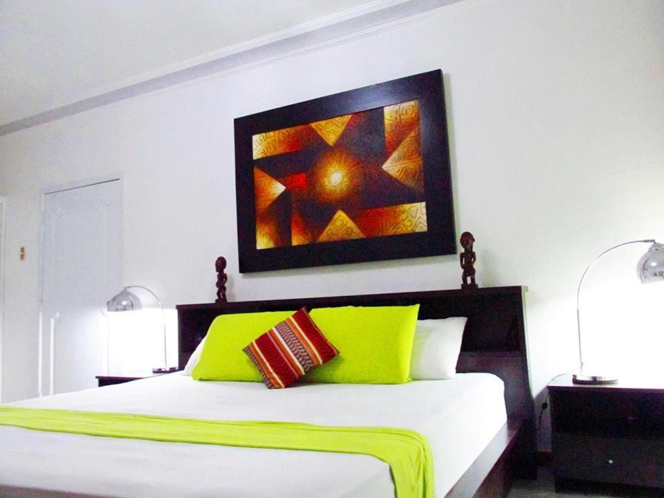Schlafzimmer mit einem Bett mit Wandgemälde in der Unterkunft Home Suite Garden in Guayaquil