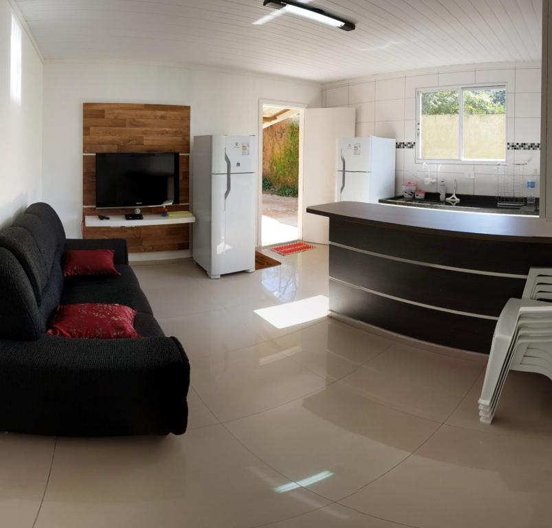 sala de estar con sofá y cocina en Lírios da Montanha, en Santo Antônio do Pinhal