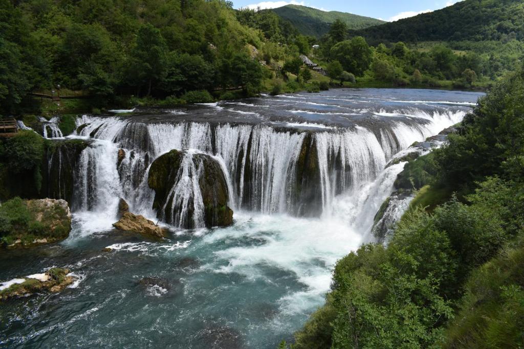 a waterfall in the middle of a river at Rooms Vukša in Donji Lapac