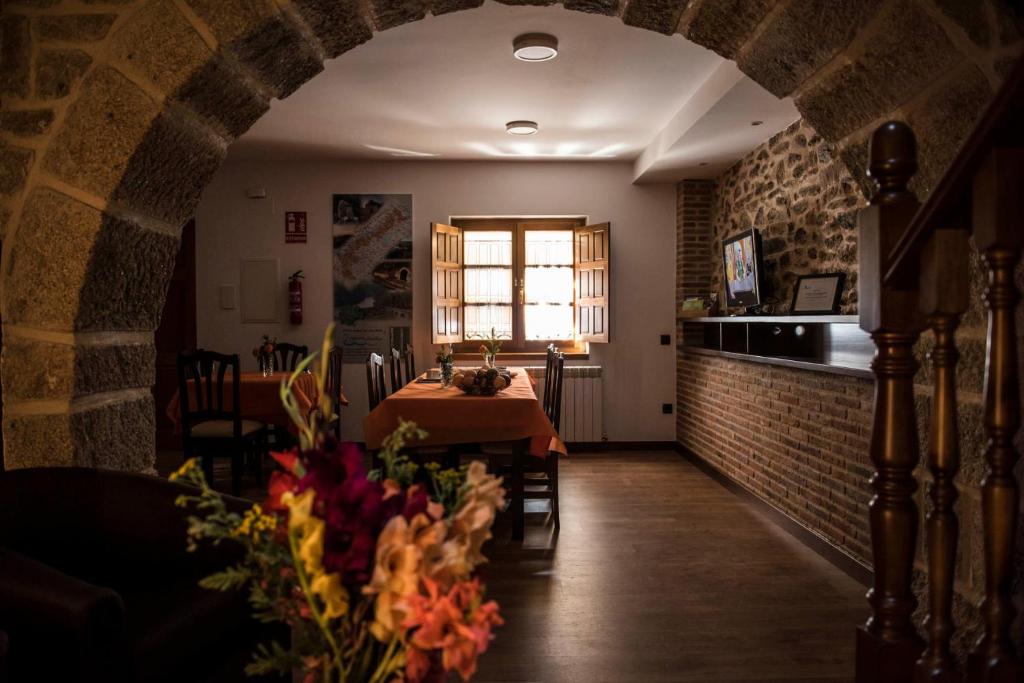 a dining room with a table and a brick wall at Dos Aguas Arribes in Fermoselle