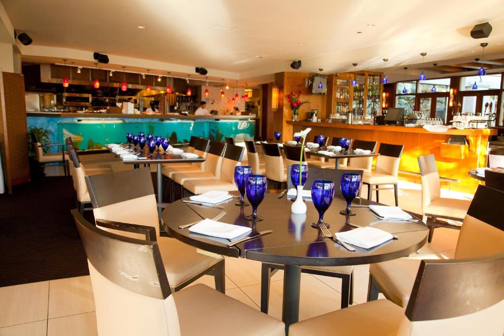 a restaurant with tables and chairs and a bar at Granville Island Hotel in Vancouver