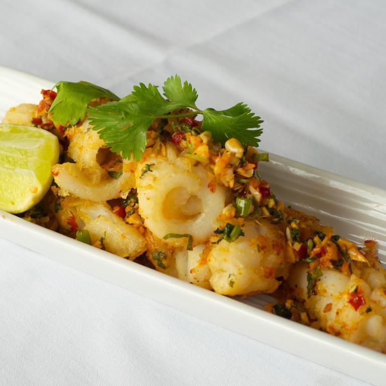 a white bowl of shrimp with parsley and a lime at Granville Island Hotel in Vancouver