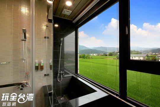 a bathroom with a window with a view of a field at 宜人生活溜滑梯親子民宿 Easylife B&amp;B in Dongshan