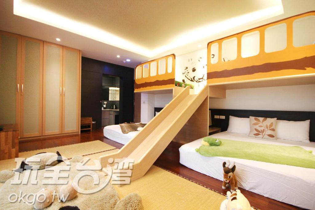 a bedroom with two bunk beds in a room at 宜人生活溜滑梯親子民宿 Easylife B&amp;B in Dongshan