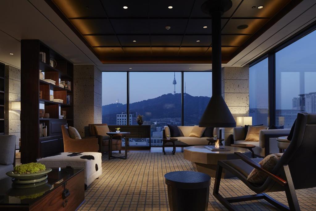 a lobby with chairs and tables and a large window at Royal Hotel Seoul in Seoul